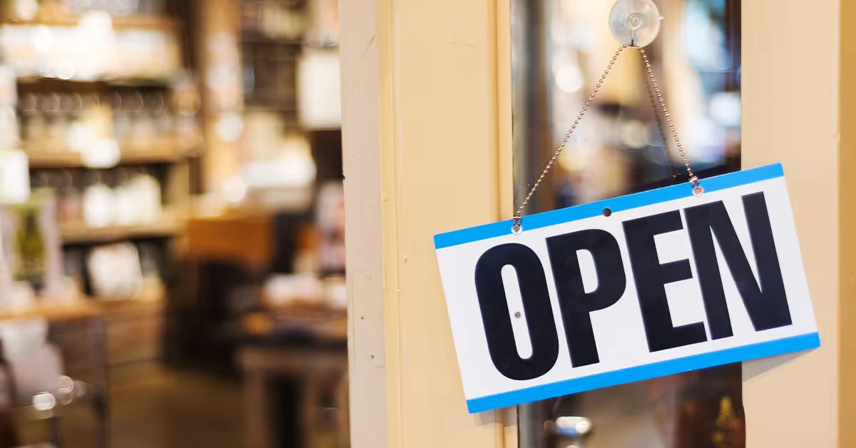 Open sign hanging in a small business storefront window